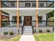 Charming home featuring a welcoming front porch with natural wood accents and a decorative front door at 490 Third Ave, Scottdale, GA 30079