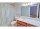 Bathroom featuring a single sink vanity, toilet, and shower with patterned curtain at 1005 Berkeley Woods Dr, Duluth, GA 30096