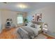 Staged bedroom with hardwood floors, neutral decor, desk, and ample natural light at 1005 Berkeley Woods Dr, Duluth, GA 30096