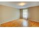 A well-lit bedroom with hardwood floors and a window dressed with curtains at 1005 Berkeley Woods Dr, Duluth, GA 30096