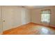 Empty bedroom with hardwood floors, closet, and a window that provides natural light at 1005 Berkeley Woods Dr, Duluth, GA 30096