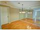 Dining area with wooden floors, a chandelier, and mirror accent wall at 1005 Berkeley Woods Dr, Duluth, GA 30096