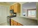 Kitchen featuring wood cabinets, stone countertops, and a view into the living area at 1005 Berkeley Woods Dr, Duluth, GA 30096