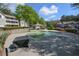 Outdoor pool area with surrounding greenery and community buildings in background at 1005 Berkeley Woods Dr, Duluth, GA 30096