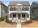 Charming two-story home featuring a symmetrical design, covered front porch, and landscaped front yard at 1157 Hannaford Ln, Johns Creek, GA 30097