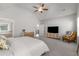 Spacious main bedroom with a ceiling fan, TV, a sitting chair and light-filled with neutral decor at 1157 Hannaford Ln, Johns Creek, GA 30097