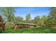 Quaint brick home with green yard, black window shutters, and mature trees surrounding the property at 681 Counsel Dr, Marietta, GA 30068
