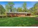 Charming brick home with a well-manicured lawn, carport, and mature trees at 681 Counsel Dr, Marietta, GA 30068