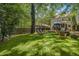 Spacious backyard with green grass, mature trees, patio furniture, and the exterior of the house at 1123 Seaboard Nw Ave, Atlanta, GA 30318