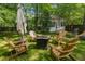 Serene backyard with Adirondack chairs and an outdoor fireplace, complemented by a small outbuilding at 1123 Seaboard Nw Ave, Atlanta, GA 30318