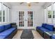Cozy patio featuring wicker furniture, blue cushions, tiled floor, and glass pane doors leading to the outdoors at 1123 Seaboard Nw Ave, Atlanta, GA 30318