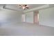 Expansive carpeted bedroom featuring tray ceilings and multiple windows at 616 Leafy Branch Way, Mcdonough, GA 30253