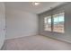 Cozy bedroom featuring neutral walls, plush carpeting, and bright windows with a serene outdoor view at 616 Leafy Branch Way, Mcdonough, GA 30253
