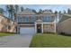 Traditional two-story brick home with a two-car garage and manicured lawn on a sunny day at 616 Leafy Branch Way, Mcdonough, GA 30253
