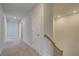 Bright hallway with carpet flooring and neutral paint, stairs visible on the side at 616 Leafy Branch Way, Mcdonough, GA 30253
