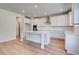 Modern kitchen boasts white cabinets, stainless steel appliances, and a large island at 616 Leafy Branch Way, Mcdonough, GA 30253