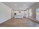 Open-concept living space with hardwood floors, leading to a stylish kitchen at 616 Leafy Branch Way, Mcdonough, GA 30253