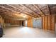 Unfinished basement with exposed wood framing, concrete floor, and a door to the outside at 7586 Jennadee Dr, Fairburn, GA 30213