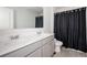 Bathroom with double sinks set in gray cabinets, a large mirror, and a shower with a black curtain at 7586 Jennadee Dr, Fairburn, GA 30213
