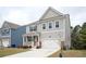 Stylish two-story home with gray siding, white trim, and a two-car garage with a concrete driveway at 7586 Jennadee Dr, Fairburn, GA 30213