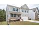 Attractive two-story home featuring gray siding, a welcoming front porch, and an attached two-car garage at 7586 Jennadee Dr, Fairburn, GA 30213