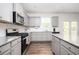 Modern kitchen boasts granite countertops, stainless steel appliances, and ample cabinet space at 7586 Jennadee Dr, Fairburn, GA 30213
