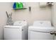 Laundry room with white washer and dryer, complemented by wire shelving above at 7586 Jennadee Dr, Fairburn, GA 30213