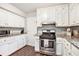 Bright kitchen with stainless steel appliances, granite countertops, and white cabinetry at 835 Ridge Ave, Stone Mountain, GA 30083
