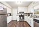 Bright kitchen featuring white cabinets, granite counters, stainless steel appliances and wood-look floors at 835 Ridge Ave, Stone Mountain, GA 30083