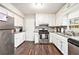 Bright kitchen with white cabinets, granite countertops, stainless steel appliances, and dark wood-look floors at 835 Ridge Ave, Stone Mountain, GA 30083