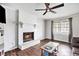 Cozy living room with a white brick fireplace, ceiling fan, and hardwood floors at 835 Ridge Ave, Stone Mountain, GA 30083