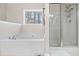 Bathroom featuring a soaking tub, glass-enclosed shower, and window view of the trees at 184 Chamberlyn Ln, Hiram, GA 30141