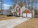Beautiful home featuring a two-car garage, long driveway, brick facade, and manicured landscaping at 184 Chamberlyn Ln, Hiram, GA 30141