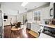 Open-concept kitchen with stainless steel appliances, white cabinets, and an adjacent dining area with backyard view at 184 Chamberlyn Ln, Hiram, GA 30141