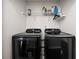 Modern laundry room featuring a black Samsung washer and dryer with white walls and a wire shelf at 184 Chamberlyn Ln, Hiram, GA 30141