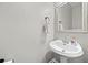 Stylish powder room showcasing a pedestal sink, mirror, and neutral wall color at 184 Chamberlyn Ln, Hiram, GA 30141