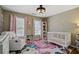Charming Bedroom featuring a crib, comfortable seating, and soft, colorful accents at 2241 Harry Brooks Nw Dr, Atlanta, GA 30318