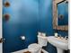 Stylish powder room features blue walls, contemporary fixtures, and a unique mirror at 2241 Harry Brooks Nw Dr, Atlanta, GA 30318