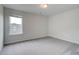 A simple, well-lit bedroom featuring a single window, gray carpet, and clean, neutral walls at 255 Arnewood Cir, Mcdonough, GA 30253