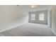Bright bedroom with neutral walls, plush gray carpet, and natural light from two windows at 255 Arnewood Cir, Mcdonough, GA 30253