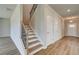 Hallway with hardwood floors leading to stairs, offering access to multiple rooms and levels at 255 Arnewood Cir, Mcdonough, GA 30253