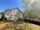 View of the side of the house with mature trees adding to the landscape on a sunny day at 262 Bomar Ln, Douglasville, GA 30134