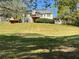 The grassy backyard with a home in the background features a small deck and storage shed at 262 Bomar Ln, Douglasville, GA 30134