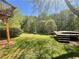 Sprawling green lawn backyard features mature trees, a storage shed, and a small wooden deck at 262 Bomar Ln, Douglasville, GA 30134