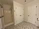 Modern bathroom featuring walk in shower, white cabinets and patterned tile flooring at 262 Bomar Ln, Douglasville, GA 30134
