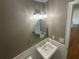 Close-up of the bathroom featuring an oval mirror, light fixture, and pedestal sink at 262 Bomar Ln, Douglasville, GA 30134
