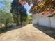 Three car garage and driveway showing backyard with mature trees on a sunny day at 262 Bomar Ln, Douglasville, GA 30134