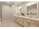 Bright bathroom featuring a double vanity with neutral countertops and cabinetry, tile floors, and ample lighting at 4900 Fairmont Way, Roswell, GA 30075