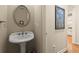 The powder room features a pedestal sink, decorative mirror, and is adorned with charming accents at 4900 Fairmont Way, Roswell, GA 30075
