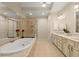 Luxurious bathroom with a soaking tub, glass-enclosed shower, and double vanity sinks at 4900 Fairmont Way, Roswell, GA 30075